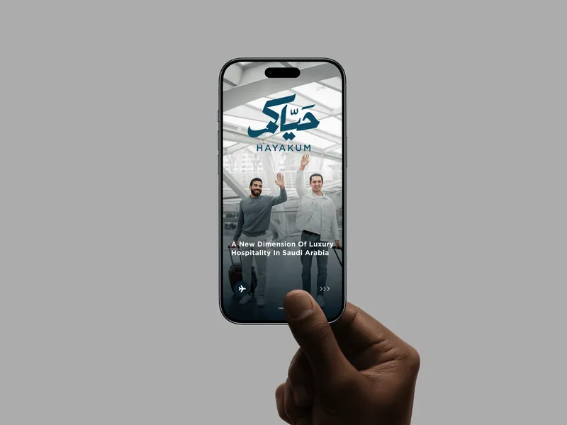 The Hayakum site on a phone, showing its Arabic wordmark over a hospitality campaign image.